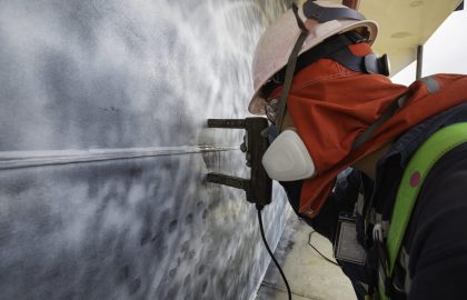 A male worker at high test steel tank butt weld carbon shell pl A male worker at high test steel tank butt weld carbon shell plate of storage tank crude oil background white contrast of magnetic field test